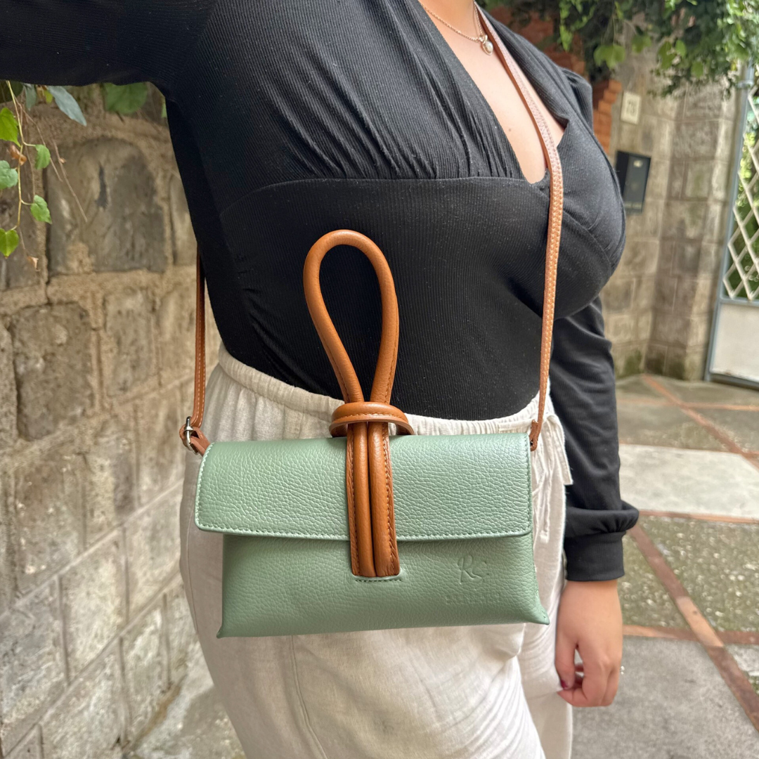 Woman modelling sage and brown knot clutch leather handbag 1