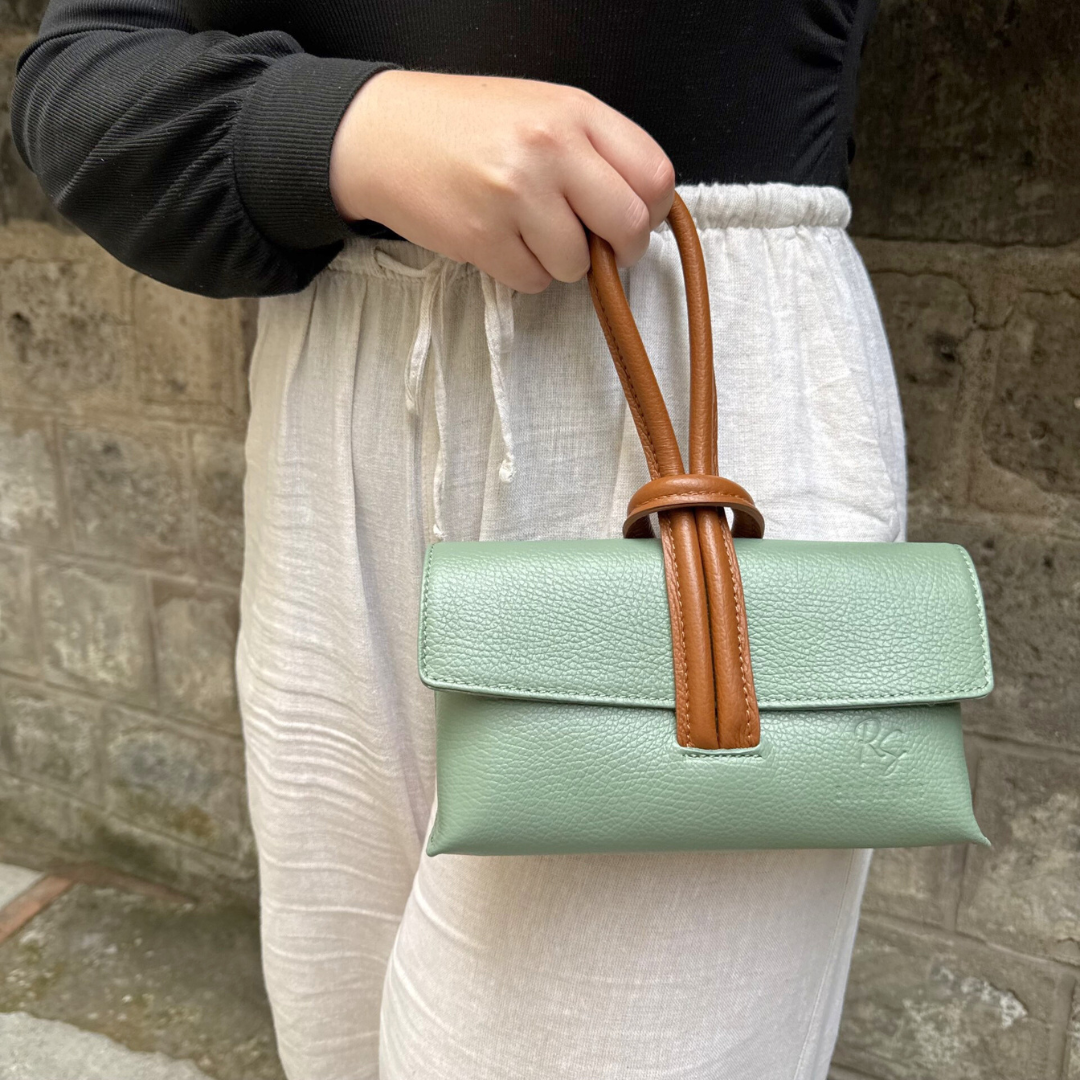 Woman modelling sage and brown knot clutch leather handbag